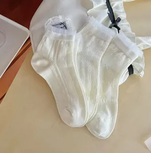 Gros plan de chaussettes en dentelle à motif de nœud et mesh blanc pour femme élégantes.