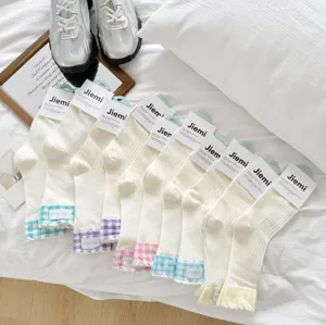 Detail view of women's mesh mid-tube socks featuring colorful plaid cuffs and breathable cotton fabric.