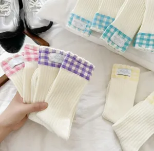 Closeup detail of cute Japanese style ribbed mid-tube socks with colorful checkered cuffs.