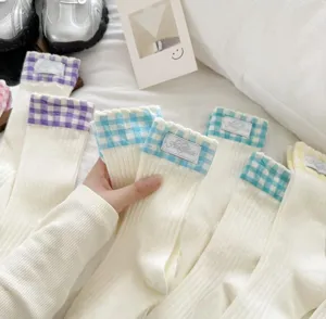 Detailed view of cute Japanese style plaid ruffle cotton mid-tube socks, soft cozy fabric.
