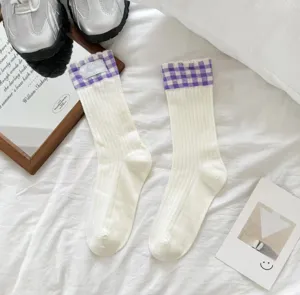 White mid-calf socks featuring purple plaid cuffs and delicate woven label, breathable cotton.