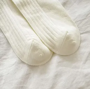 Detailed view of women's white ribbed cotton mid-calf socks showing fine knit texture.