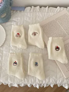 White fuzzy socks with cute animal embroidery, warm sleep floor socks for winter. Detail view.