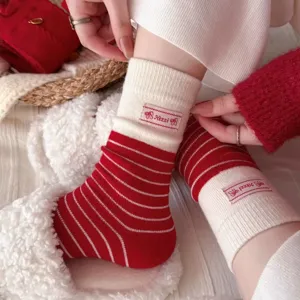 Cozy red and white striped mid-tube women socks with cute label detail for winter daily wear.
