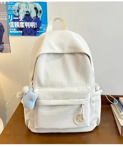 Detailed view of the white corduroy student backpack featuring a front pocket and K badge.