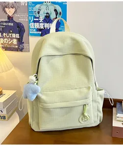 Detail view of light green casual backpack with cute star pendant and front pocket design.
