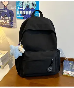 Casual black student backpack with star pendant and front pocket for daily commute and school.