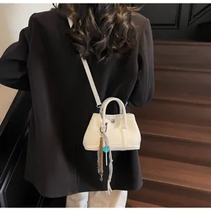 Detailansicht einer stilvollen kleinen weißen Schultertasche, schlichtes und vielseitiges Design.