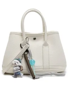 Weiße Leder-Handtasche mit Henkel und süßem Hundeanhänger für stilvolle Damen im Alltag.