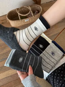 Detail shot of striped cotton socks with cute embroidery design, showcasing soft texture.