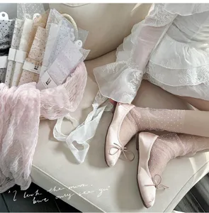 Detail shot of sheer polka dot mesh socks paired with stylish ballet flats, soft texture.