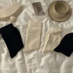 Comfortable cotton mid-calf socks in basic black and off-white colors, perfect for daily wear.