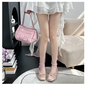 Sheer mesh polka dot mid-tube socks paired with pink satin bow ballet flats for women.
