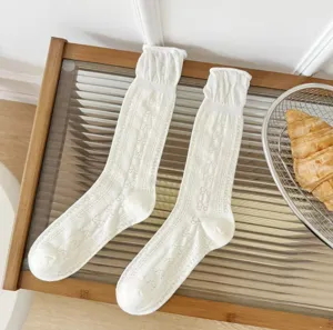 Calzini bianchi al polpaccio per donna con ricamo di fiocco e design in rete traspirante.