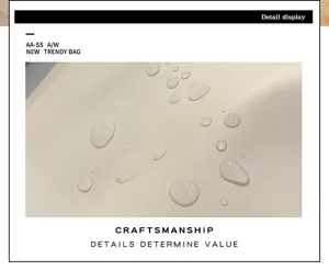 Détail du sac à dos d'affaires en cuir PU montrant une surface imperméable et de l'artisanat.