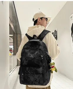 Detail shot of a minimalist nylon backpack with letter print, worn by a model in hallway.