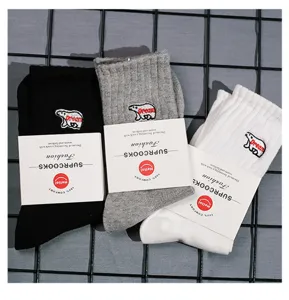Detailed view of casual embroidered mid-calf socks in black, grey, and white with chic bear motif.