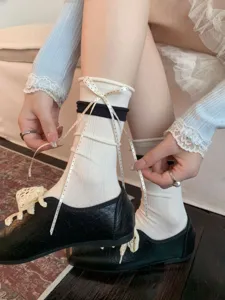 Detail view of white cotton stack socks with black stripe and cute bow ribbon for ballet style.