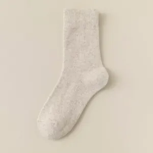 Close-up view of a cozy beige cashmere blend mid-calf winter warm knit sock texture.