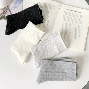 Detailed view of breathable cotton mid-calf socks with delicate hollow clover patterns.