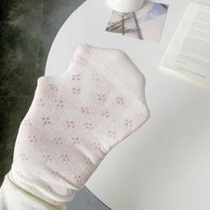 Close-up detail of white mesh cotton women socks with delicate hollow clover pattern.