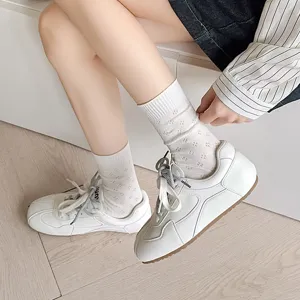 Close-up detail shot of women's white mid-tube socks featuring breathable hollow clover mesh.
