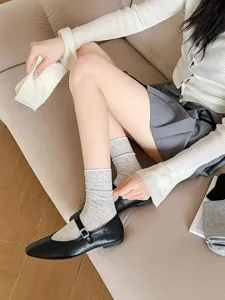 Detail shot of stylish cream white hollow-out clover mesh mid-calf socks for women.