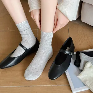 Close-up detail of women's breathable hollow clover mesh crew socks paired with black shoes.
