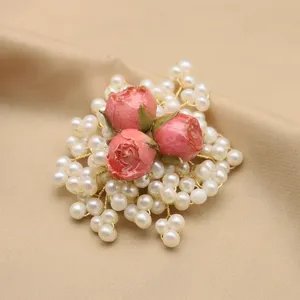 Exquisite pearl brooch featuring pink resin rose flowers and delicate gold wire, elegant retro style.