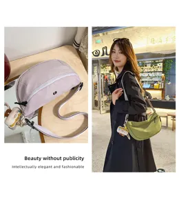 Casual daily crescent bag detail showing fabric texture, adjustable strap and cute plush pendant.