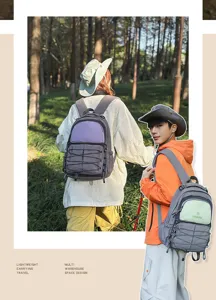 Spacious color-block backpack with multi compartments and front bungee cords for outdoor travel.