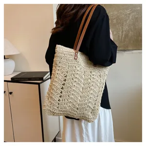 Vista dettagliata della borsa tote in paglia casual con manici in pelle per le vacanze.