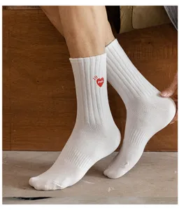 White ribbed mid-calf socks featuring a distinctive red heart embroidered detail for streetwear.