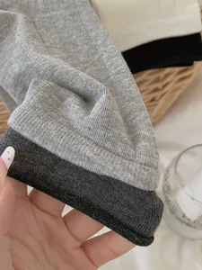 Grey cuffed mid-calf socks detail shot, cozy knitted texture, perfect for autumn winter.