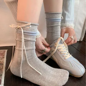 Grey ribbed mid-calf socks featuring an elegant white polka-dot bow, perfect balletcore style.