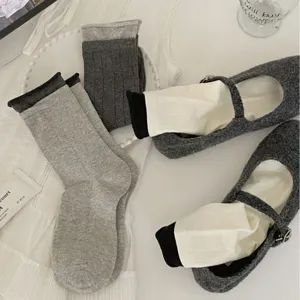 Women mid-tube socks and grey flat leather shoes set, casual solid color fashion footwear.
