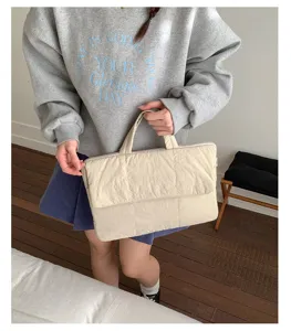Padded quilted laptop handbag detail, minimalist solid color commuter business bag.