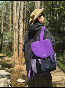 Vue detaillee d'un sac a dos violet et noir elegant porte par un modele en plein air