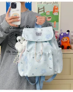 Detailansicht eines süßen hellblauen Rucksacks mit Sternenmuster und flauschigem Plüschtier.