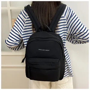 Detailansicht des lässigen schwarzen Rucksacks aus Canvas mit stilvollem Buchstaben-Print.