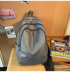 Détail de sac à dos d'affaires en PU gris, montrant la conception multi-poches quotidienne.