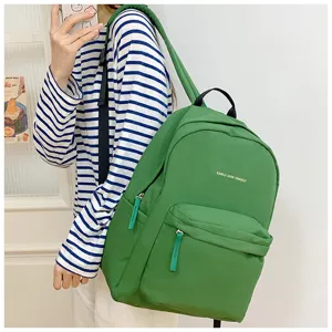 Detailansicht des grünen Studentenrucksacks mit minimalistischem Buchstabenprint.