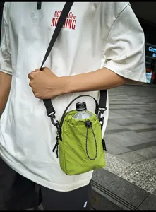 Detailed view of the green casual drawstring bucket bag worn casually outdoors with strap.