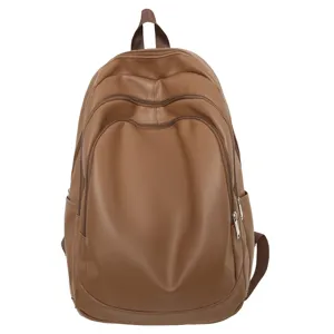 Vue détaillée du sac à dos en cuir PU marron montrant texture lisse, zips et compartiments.