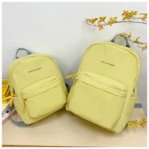 Hellgelber Studentenrucksack mit Buchstabenprint, großer Schulranzen für den täglichen Gebrauch.