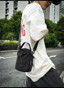Casual minimalist black drawstring bucket bag with shoulder strap for women daily commuting.
