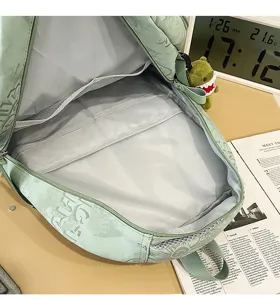 Detailed interior view of green nylon school backpack showing multiple storage compartments.
