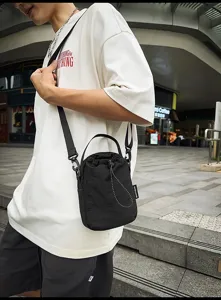 Casual minimalist black drawstring bucket bag for women, lightweight nylon crossbody shoulder bag.