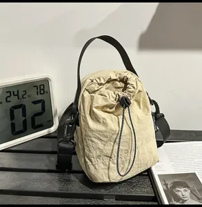 Casual minimalist drawstring bucket bag for women, lightweight solid color crossbody shoulder bag.