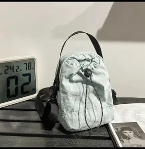 Detail view of casual minimalist candy color drawstring bucket bag with black strap for women.